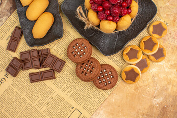 Tasty cake different biscuits on brown plate on mixed color background