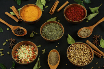 Wide variety spices and herbs on background of black table