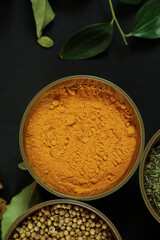 Wide variety spices and herbs on background of black table