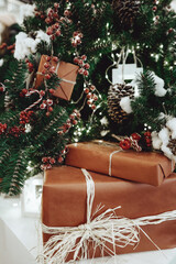 New Year's gifts under the Christmas tree with red berries and decorations