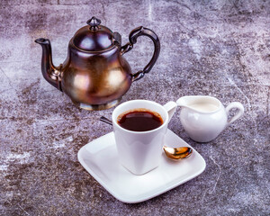 Espresso coffee in white porcelain cup and cream in a portioned jug