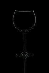 Elegant red wine glass silhouette on black background.