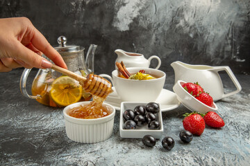 front view sweet honey with tea and olives on dark floor morning food breakfast