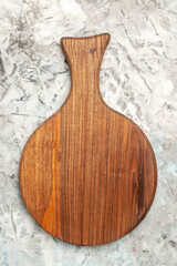 Vertical view of brown wooden cutting board on ice background