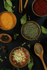 Wide variety spices and herbs on background of black table