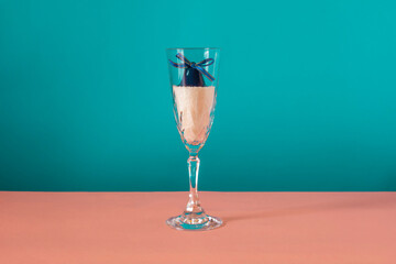 Bell inside the glass on pink and blue background. Winter concept