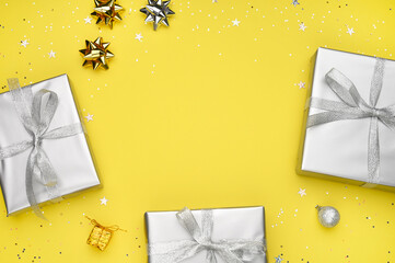Gift boxes, gray decorations on yellow background and place to the text. Trendy color. Christmas,...