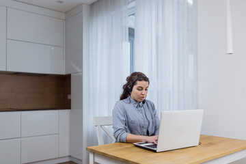 Woman talking on a headset through a laptop 