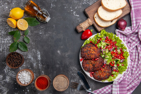 top view meat cutlets with salad and bread on the grey background food meal dish photo