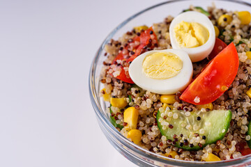 bowl of healthy quinoa with vegetables on a white background