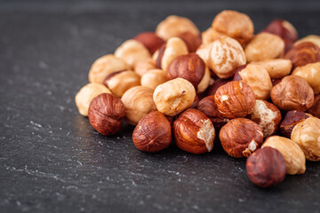fresh natural hazelnuts on a dark stone background