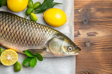top view fresh fish with lemons on brown desk food seafood ocean dish