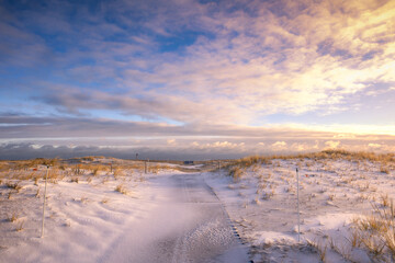 Snowy path leading to the beach under golden light. Robert Moses State Park - Fire Island New york - obrazy, fototapety, plakaty