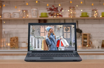 Fototapeta na wymiar Happy beautiful girl with shopping bags in her hands against the background of the Christmas house on the monitor screen . Christmas, x-mas, shopping, sale, gifts, concept.Safe Online shopping!