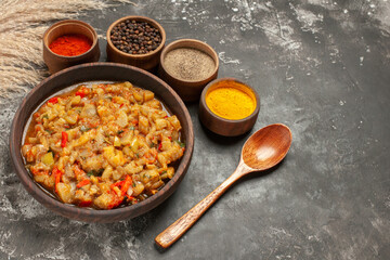 bottom view roasted eggplant salad in bowl different spices in small bowls spoon on dark background free space