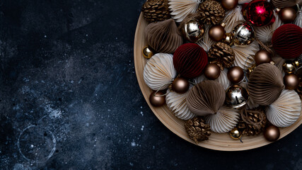 beige Christmas tree decorations on the plate on the navy blue table