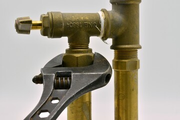 Llave ajustable apretando una tuerca en una instalación de tuberías de agua