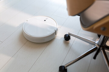Robotic vacuum cleaner hoovering the floor at home