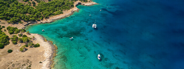 Fototapeta na wymiar Aerial drone ultra wide photo of exotic bay of Moni island visited by yachts and sail boats, Aegina island, Saronic gulf, Greece
