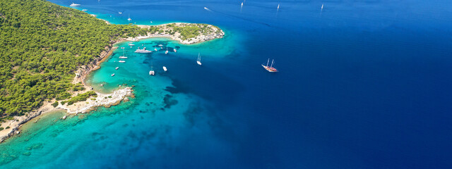 Aerial drone ultra wide photo of exotic bay of Moni island visited by yachts and sail boats, Aegina...