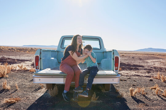USA, Arizona, Mother with son (6-7) sitting on tailgate of pick-up truck