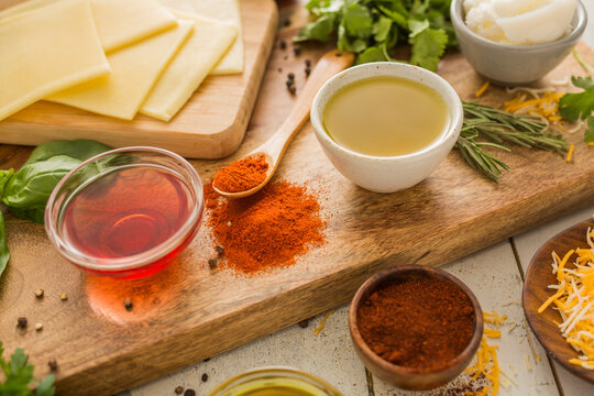 Spices, olive oil, vinegar and cheese on cutting board