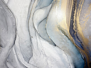 Abstract blue and grey background with beautiful smudges and stains made with alcohol ink and gold...