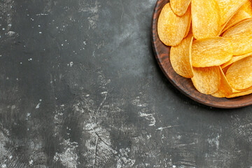 Half shot of delicious homemade potato chips on a brown plate on gray background stock image