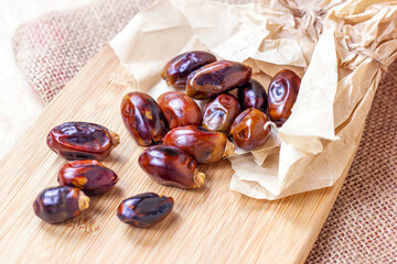 Sweet dried dates on light  wooden background in the kitchen.