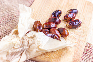 Sweet dried dates on light  wooden background in the kitchen.