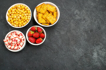 top view fresh strawberries with different snacks on dark background sweet cracker photo