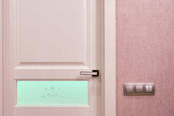 Pink door with turquoise glass. Concept of interior elements.