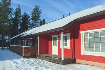 A view of cozy wooden scandinavian cabin cottage chalet house covered in snow near ski resort in...