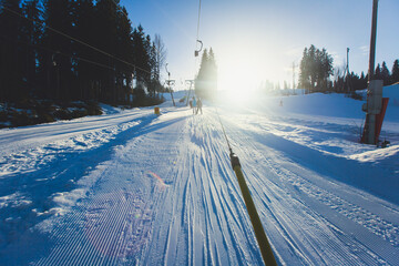 Beautiful cold mountain view of ski resort, sunny winter day with slope, piste and ski lift, with...