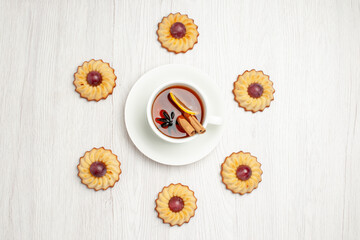 Obraz na płótnie Canvas top view yummy grape cookies with cup of tea on a white background sweet dessert biscuit pie