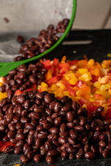 Corn, black beans and bell peppers being prepared for a meal.