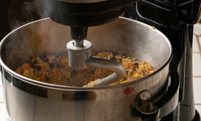 Quinoa salad being mixed in a bowl. It is steaming hot!