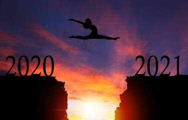 Silhouette of Girl Leaping Over Cliff at Sunrise From 2020 to New Year 2021