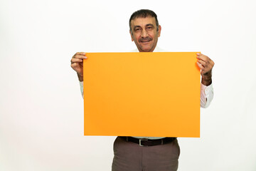 Man holding an orange banner in his hand. It can be written on. She is dressed in a white shirt and fabric pants. Isolated image white background.