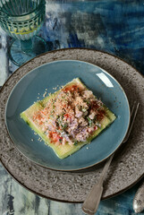 Bulgur and chicken stomachs salad on cucumbers, sprinkled with sesame seeds.