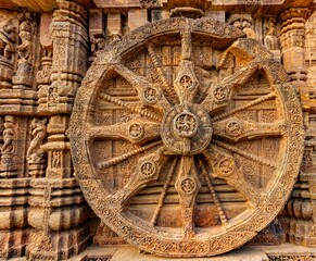 Chariot Wheel at Sun Temple, Konark, Odisha, India; each wheel of diameter 9 feet 9 inches,  having 8 wide spokes and 8 thin spokes, with beautiful carvings on rims of Hindu Gods and Goddesses; 