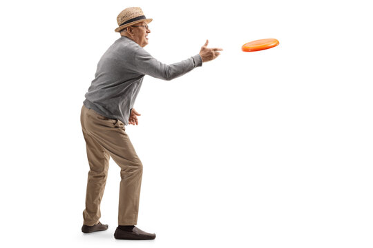 Full length profile shot of an elderly gentleman throwing a frisbee