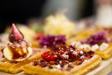 Waffles on board decorated with bananas and strawberries
