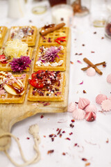 Waffles on board decorated with bananas and strawberries
