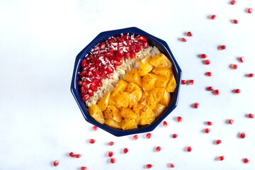 Porridge with pomegranate seeds, mandarins and coconut shavings. Healthy Eating. A healthy, fruity meal.