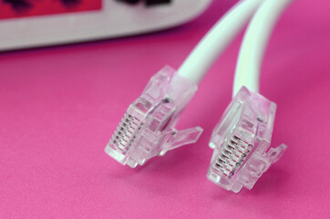 Internet router and Internet cable plugs lie on a bright pink background. Items required for...