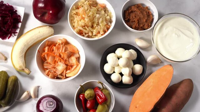 Probiotic and prebiotic such as pickles, sauerkraut, kimchi, miso, fruits good for and healthy gut and immunity. Fermented foods act as antistress. Healthy diet concept. Top view. Camera movement. 4K