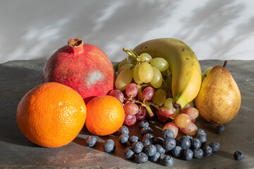still life with a bunch of grapes ,oranges ,pomegranate,banana and blueberies