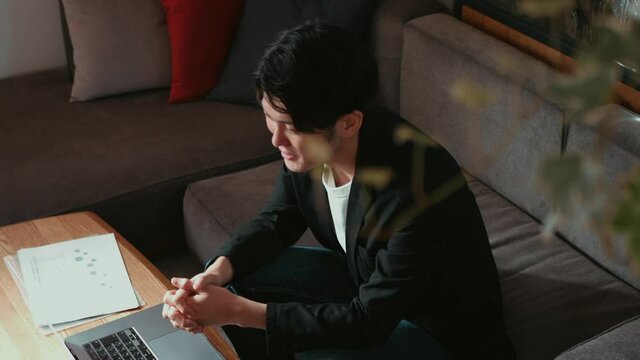 リビングのソファでテレワークをする男性