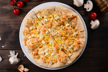 Speciality Italian food Four Cheeses Pizza topped with mozzarella, emmental, gorgonzola and goat milk cheese, Pizza 4 cheeses on a dark wooden background